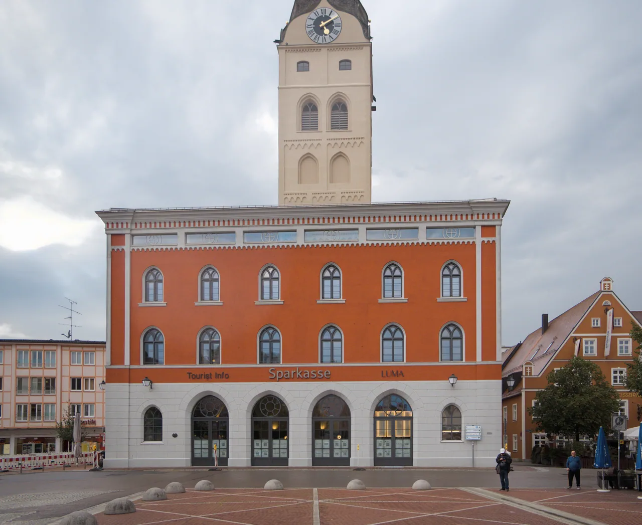 Heutige Ansicht der Schrannenhalle mit roter Fassade und Stadtturm in Erding